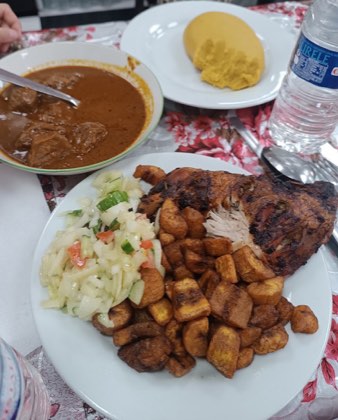 Poulet, alloco et salade dans une assiette, foutou banane et bol de sauce à côté